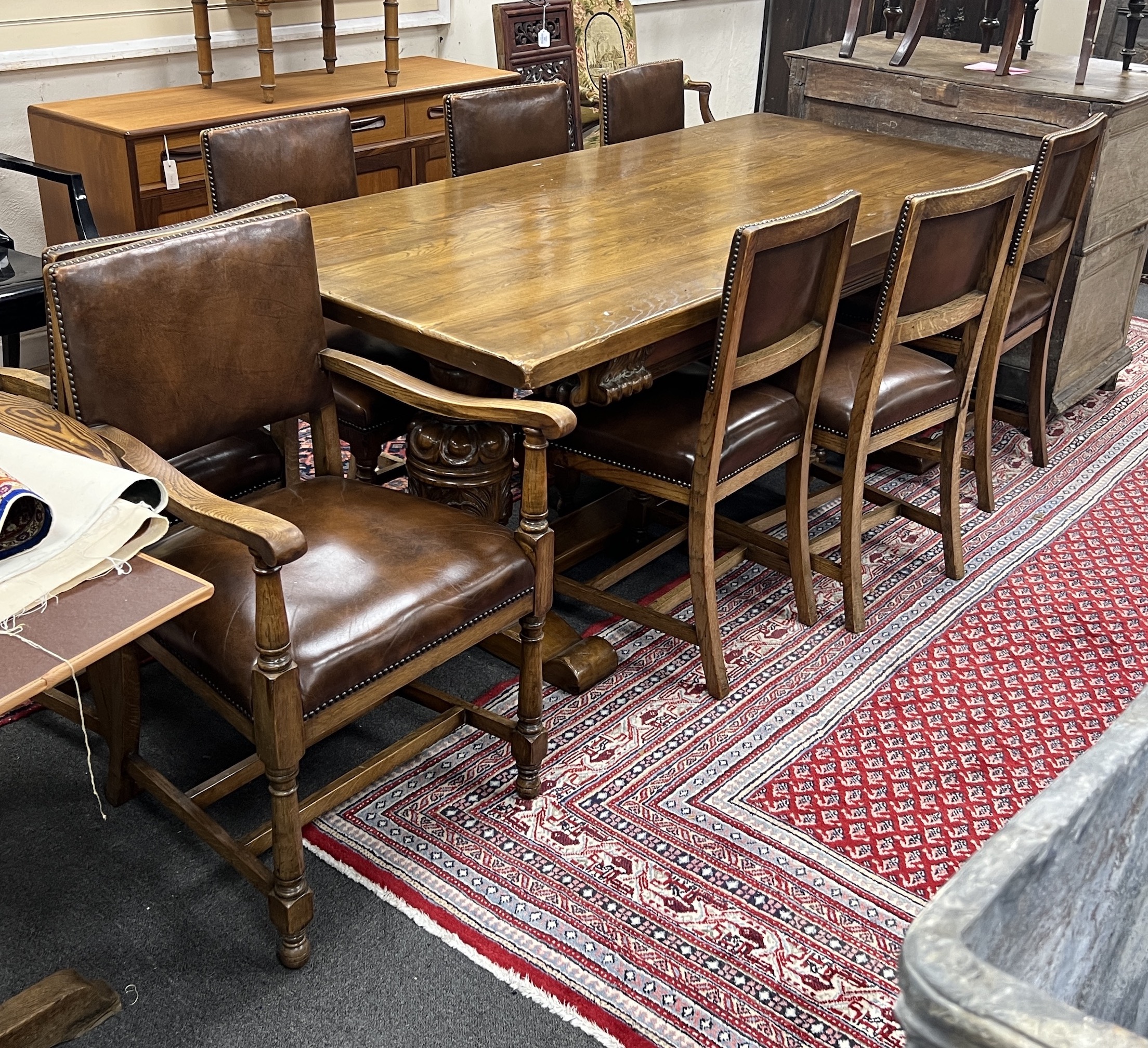 An 18th century style oak refectory dining table, length 198cm, height 76cm and eight oak dining chairs, two with arms